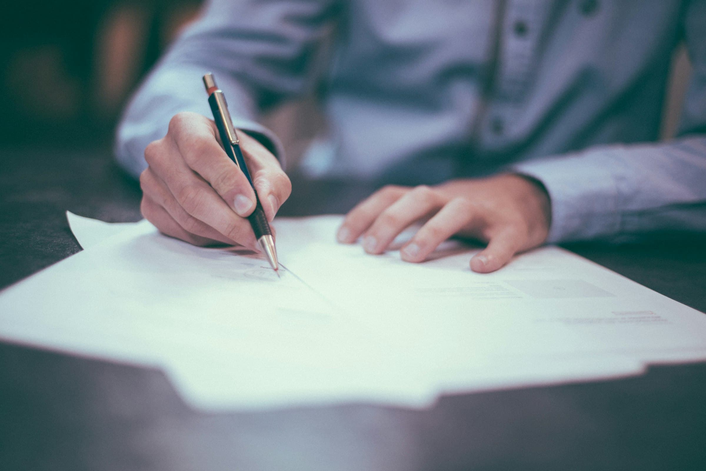 Hand schrijft met een pen op een document