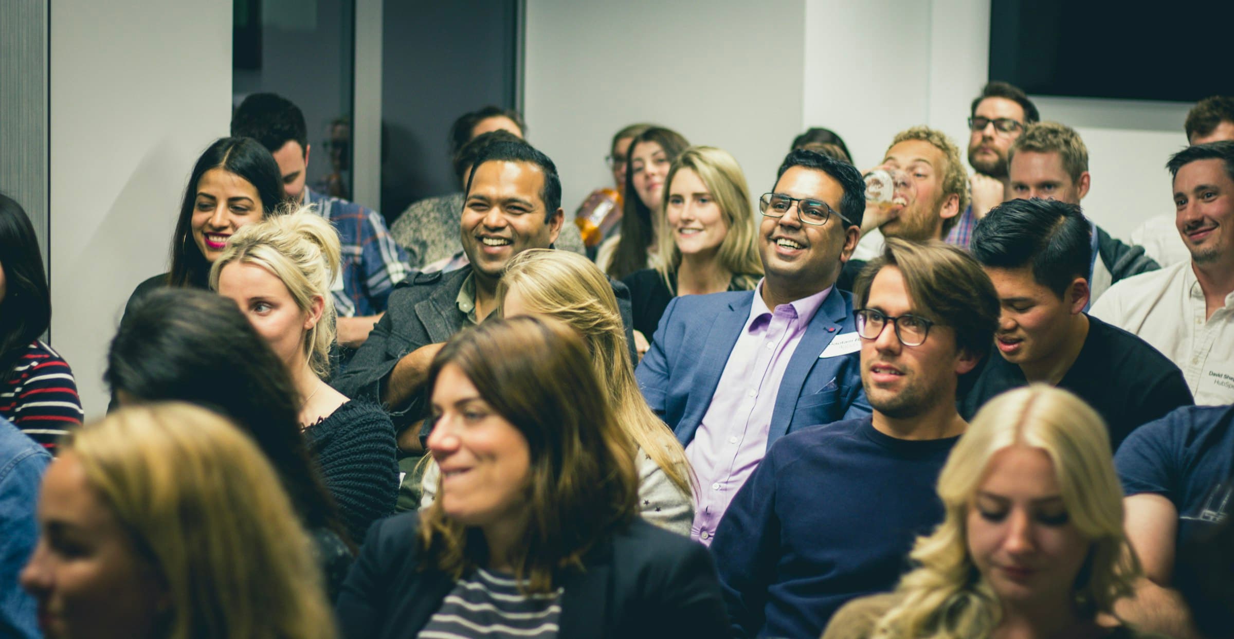 Volwassenen luisteren aandachtig en glimlachend tijdens een seminarie