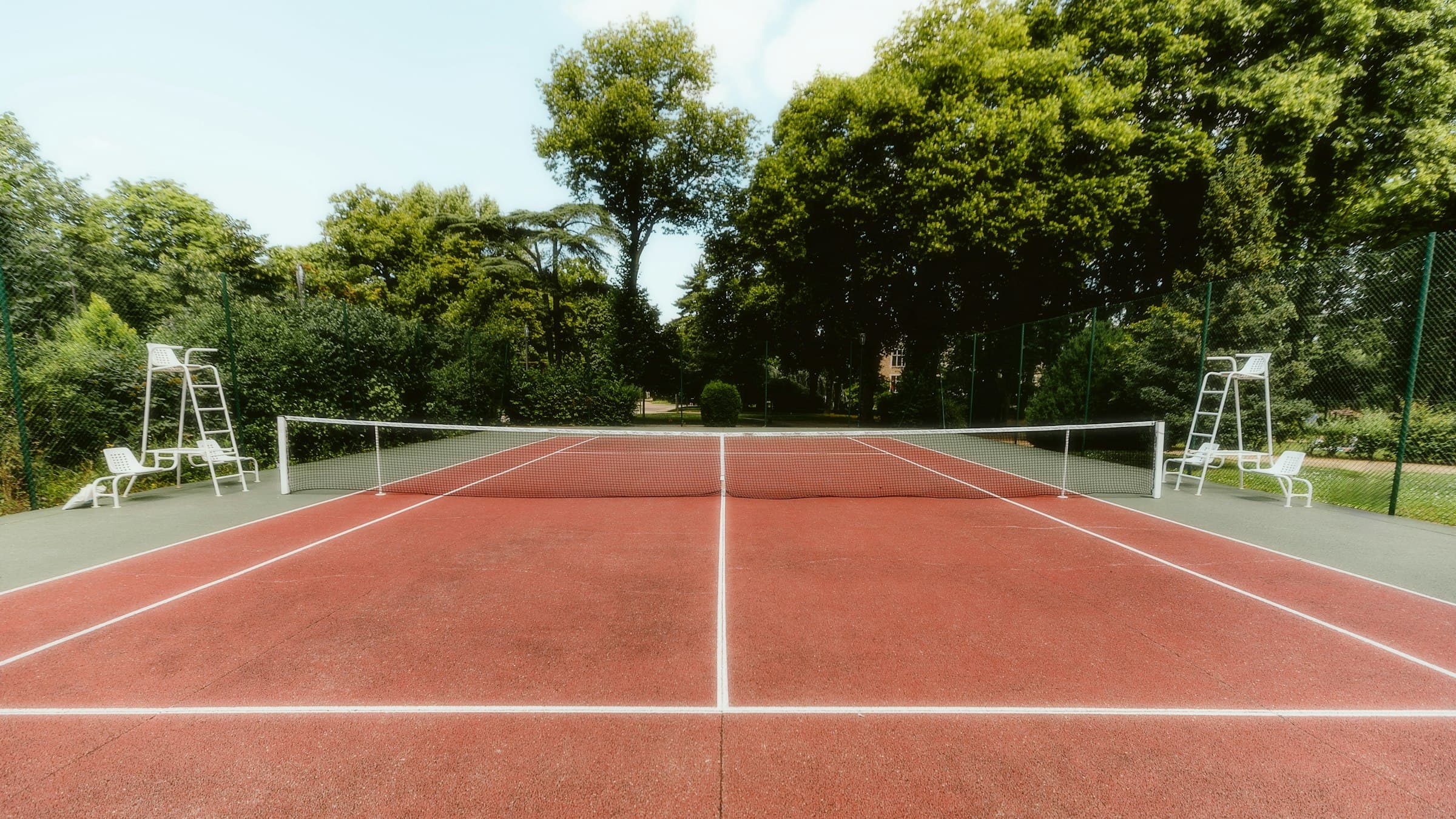 Tennisbaan met omheining op een sportterrein
